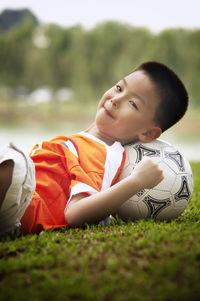 Portrait of boy reclining on ball at playground