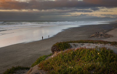 Scenic view of beach against sky during sunset