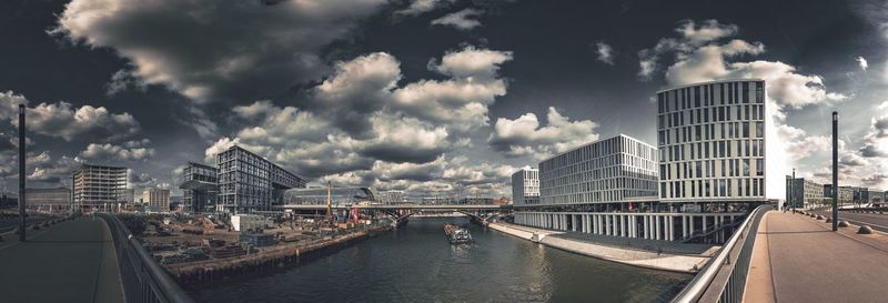 Panoramic view of river amidst buildings against sky