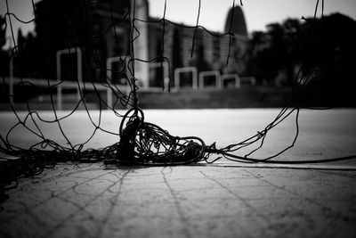 Close-up of torn net with building in background