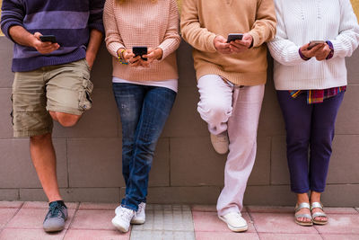 Low section of man and woman using mobile phone