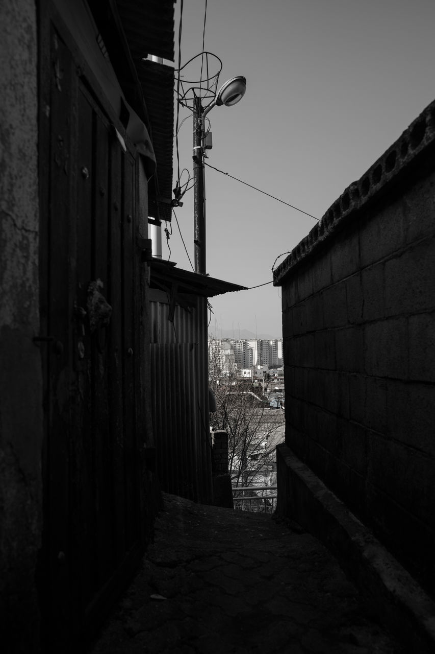 STREET AMIDST BUILDINGS AGAINST SKY IN CITY