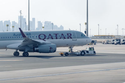 Airplane on airport runway against sky