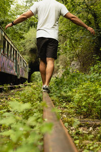 Man walking on the abandoned train track. undergrowth person
