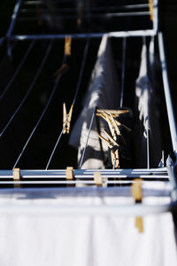 Close-up of wooden clothespins on a rack standing outdoors in light and shadows 