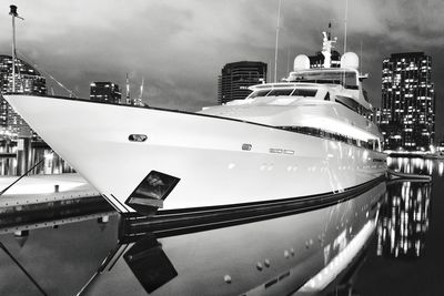 Sailboats moored on buildings in city against sky