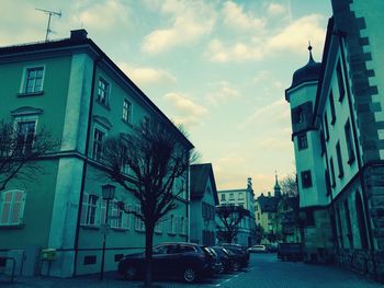 Buildings in city against cloudy sky