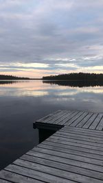 Pier on lake against sky during sunset