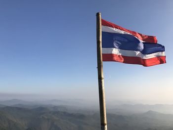 Low angle view of flag against clear blue sky