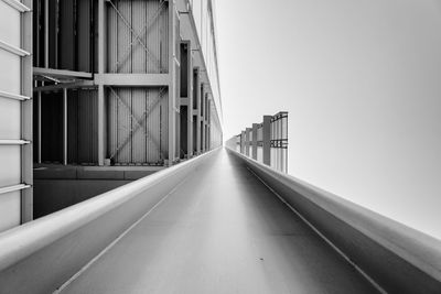 Empty road amidst buildings against clear sky