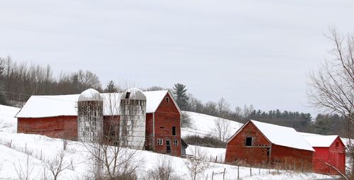 Houses on field against sky during winter