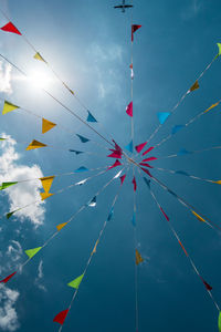 Low angle view of buntings hanging against blue sky