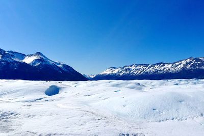Scenic view of snowcapped mountains against clear blue sky