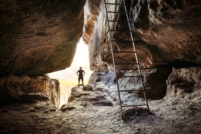 People standing on rock in cave
