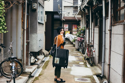 A woman holding a suitcase in the street 