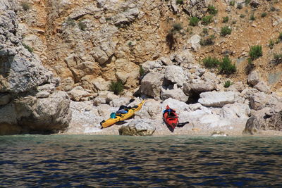 People on rock by river