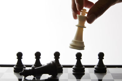 Low angle view of chess pieces against white background