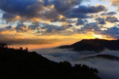 Scenic view of silhouette mountains against dramatic sky