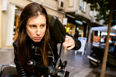 Woman looking at side-view mirror