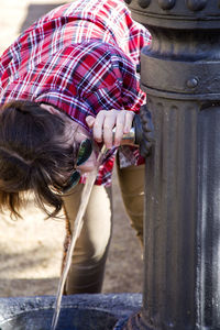 Woman drinking water from fountain