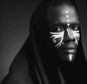 Portrait of a black man with white tribal face painting