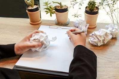 High angle view of hand holding drink on table