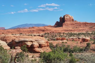 Desert landscape with small and large red rock formations and butte