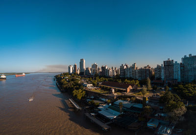 Panoramic view of sea and buildings against clear blue sky