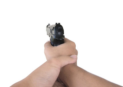 Close-up of hand holding camera over white background