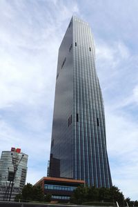 Low angle view of modern building against cloudy sky