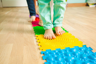Low section of boy playing with toy on floor at home