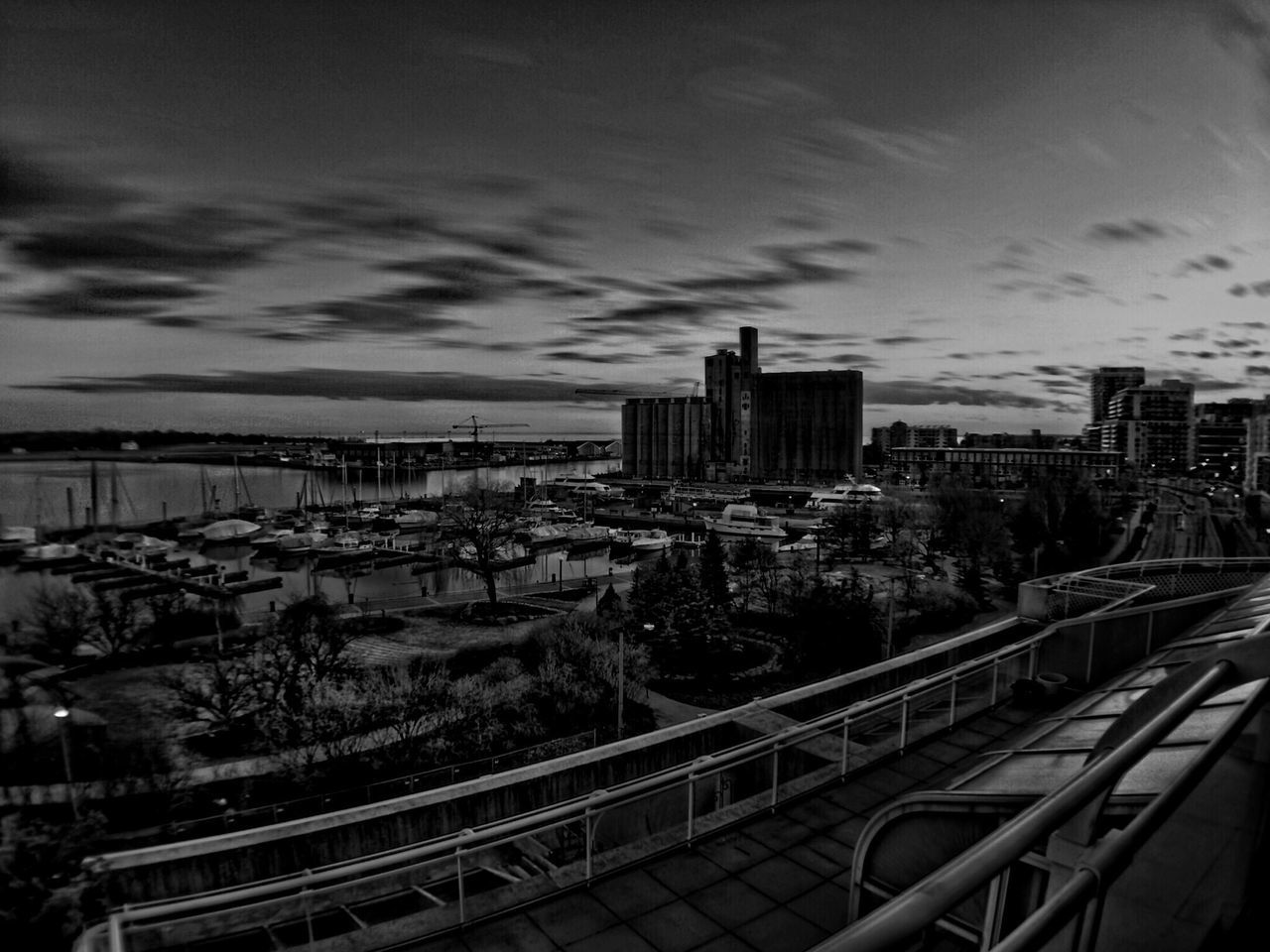 sky, building exterior, architecture, built structure, city, cloud - sky, railing, cityscape, cloudy, high angle view, cloud, outdoors, railroad track, day, no people, fence, metal, city life, transportation, residential building