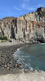 Rock formations by sea against sky