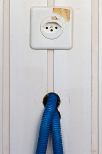 Close-up of electric outlet and wires on wooden wall