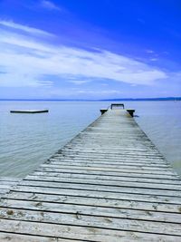 Pier over sea against blue sky