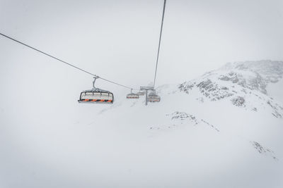 Ski lifts against clear sky during winter