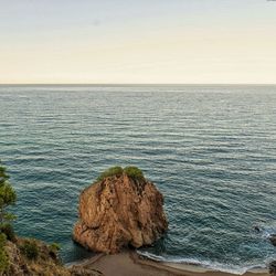 Rock formation in sea against sky