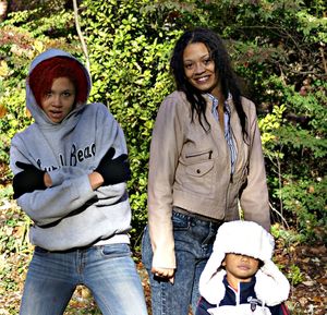 Portrait of women standing with boy against plants