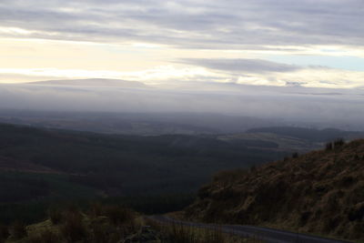 Scenic view of mountains against cloudy sky