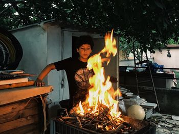 Boy standing by fire
