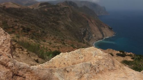 Scenic view of mountain by sea against sky