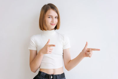 Portrait of young woman gesturing against white background