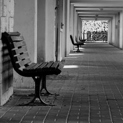 Empty bench in corridor of building