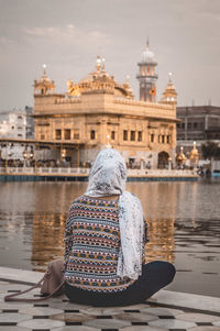 Rear view of a woman sitting against the sky