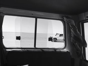 View of boat in sea seen through car window
