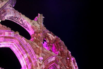 Low angle view of illuminated sculpture against sky at night