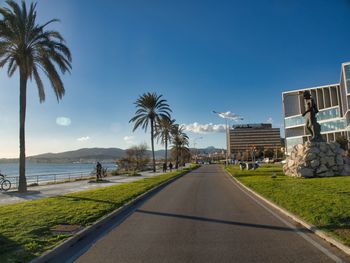 Road by sea against blue sky