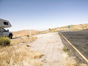 Road by landscape against clear sky