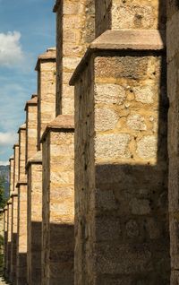 Stone wall of old building against sky