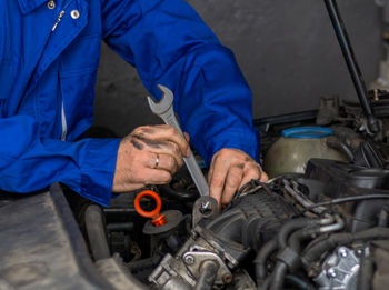 Senior experienced mechanic repairing a car at workshop